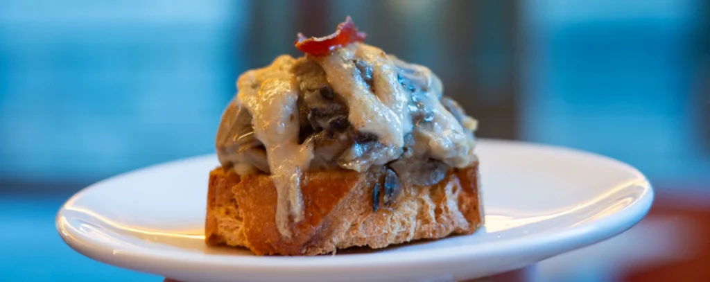 Pintxo de hongos con jamón — creamy wild mushrooms with a jamón crisp on toasted bread at El Globo, Bilbao, hero image for Issue 01