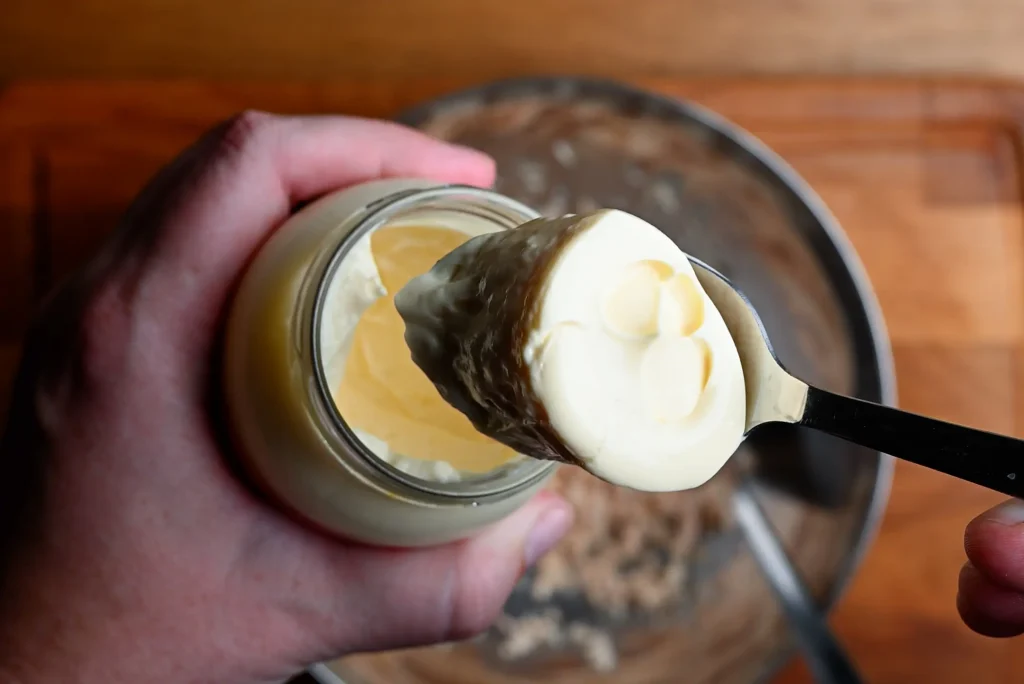 Pintxo de bonito recipe step 2 — a spoonful of mayonnaise being added from a jar into a mixing bowl