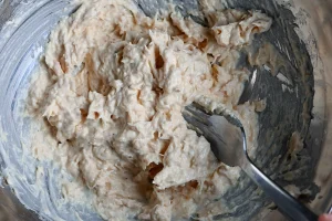 Pintxo de bonito recipe step 3 — bonito and mayonnaise mixed into a chunky pale paste in a glass bowl with a fork