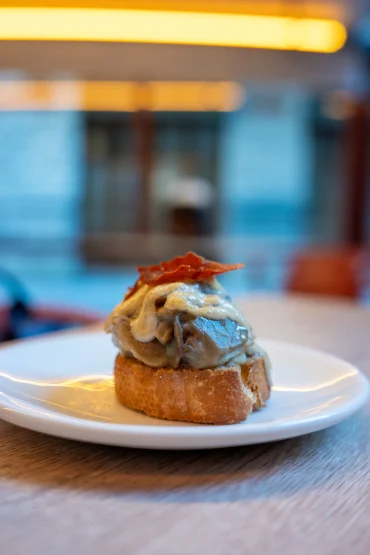 Pintxo de hongos con jamón — wild mushrooms in cream sauce with a jamón crisp on fluffy bread at El Globo, Bilbao