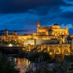 Mezquita-Catedral and Roman Bridge illuminated at night over the Guadalquivir river, Córdoba, Spain