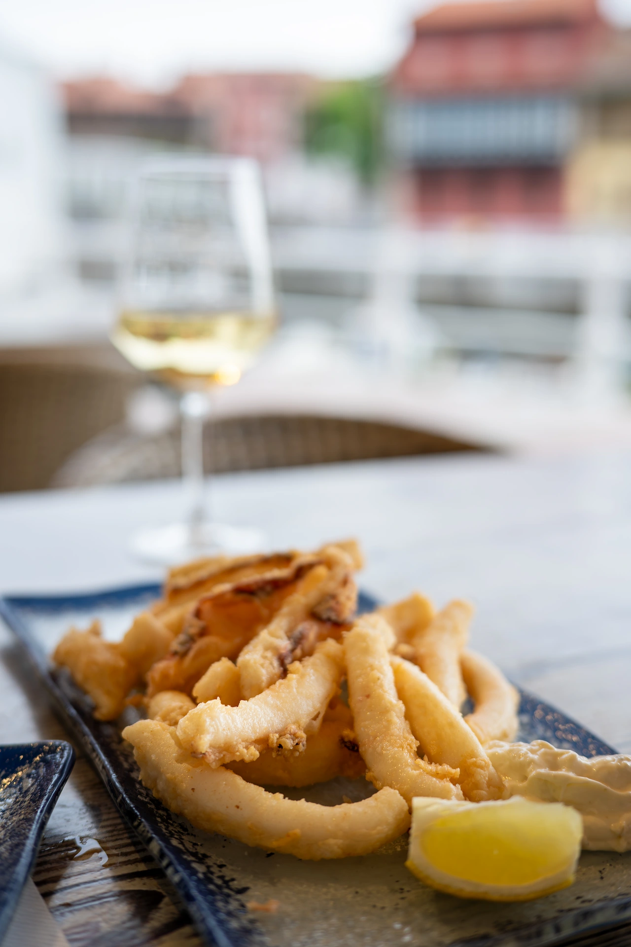 Rabas de calamar — battered squid strips on a blue ceramic plate with lemon wedge, at Sidrería Restaurante El Puerto, Llanes
