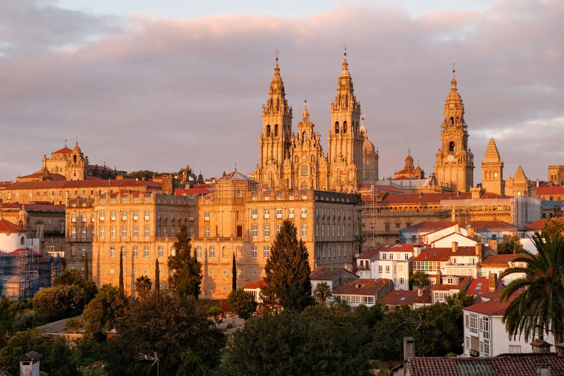Santiago de Compostela Cathedral Baroque towers glowing in warm sunset light above the old town rooftops, Santiago de Compostela, Spain