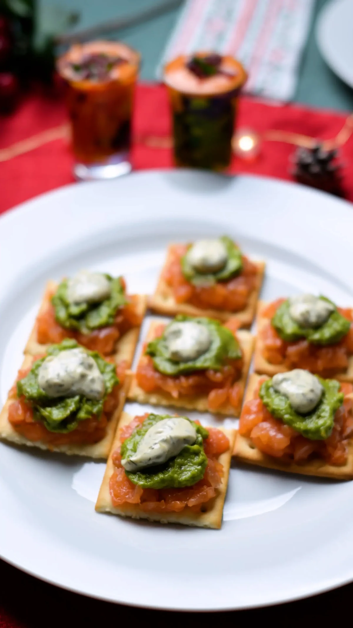 Tuna tartar on square crackers with green herb sauce and a cream quenelle on a white plate, Spain