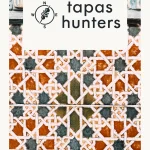 Close-up of intricate Moorish-style geometric tiles in rust orange, white, and dark grey with the Tapas Hunters logo overlaid on top.