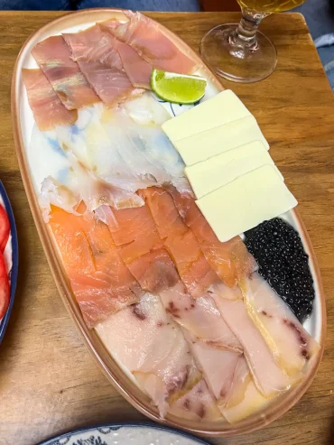 A gourmet platter of smoked salmon, smoked cod, smoked tuna, smoked swordfish, sliced butter, and black roe served at La Trastienda in Granada, Spain.