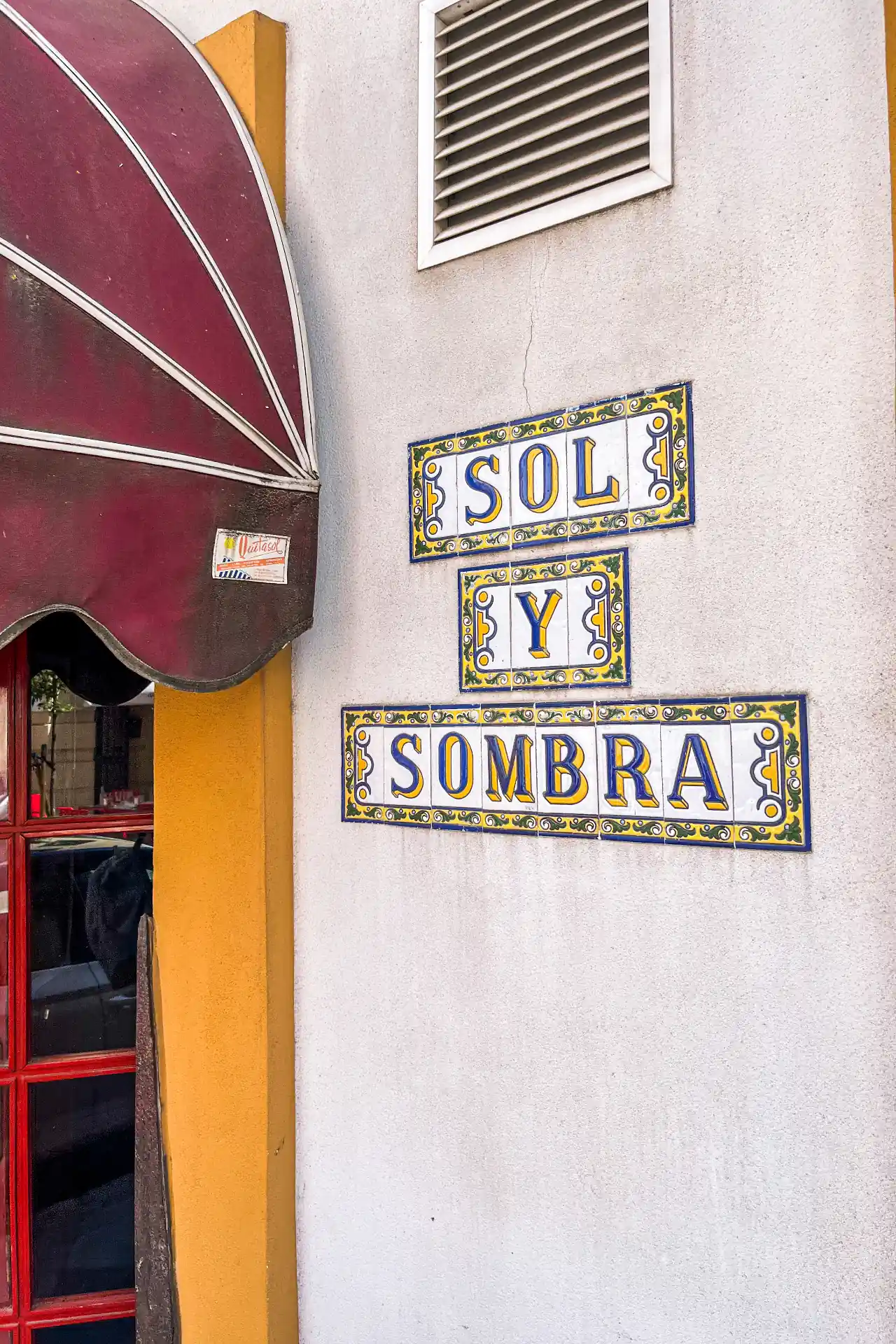 Close-up of traditional painted ceramic tile signage reading 